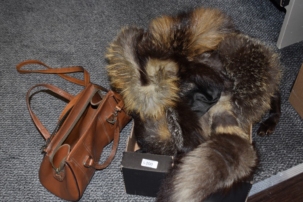 Two 1940s silver fox wraps and a tan leather shoulder bag.
