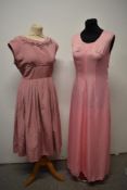 A 1950s grosgrain dress in rose pink, having full pleated skirt, beading to bust and half belt to