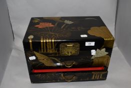 A vintage Japanese lacquered table box, having hinged lid and two drawers.