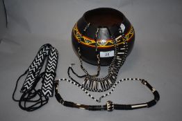 An African clay bowl, with hand painted decoration on black ground and three beaded necklaces and