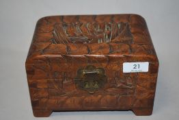 A mid century Chinese carved camphor wood jewellery box in the from of a chest, having trees and