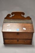 An early twentieth century oak writing box, having scrolled finial to back, brass studded leather