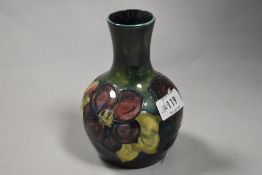 A mid century Moorcroft vase, having tube lined anemone pattern on green and teal ground.