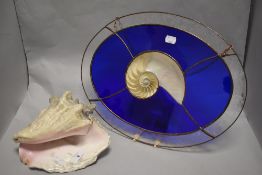 An interesting leaded glass and nautilus shell suncatch, of oval form with central nautilus shell