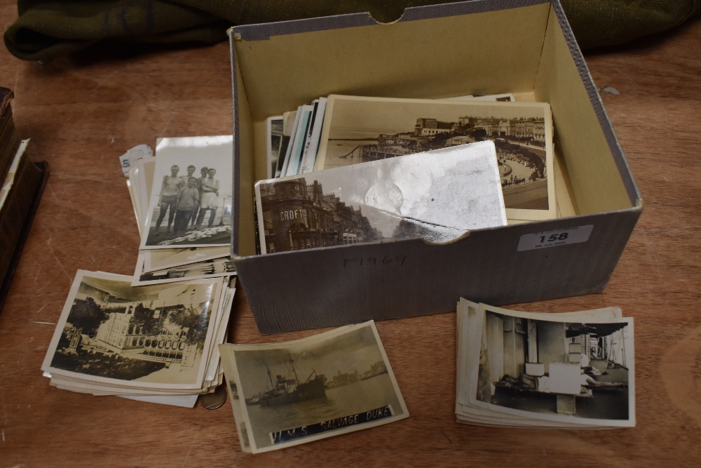 A box of assorted vintage photographs and postcards, including landmarks in...