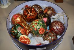 A collection of festive papier mache christmas baubles and decorations