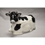 A Japanese 'Otagiri' porcelain Friesian Cow form biscuit barrel, the upper quarter forming the cover