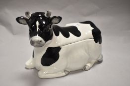 A Japanese 'Otagiri' porcelain Friesian Cow form biscuit barrel, the upper quarter forming the cover