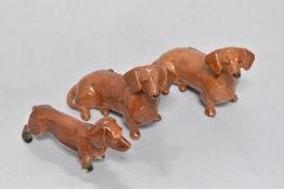 Three Dachsund studies, including two Beswick pottery studies.