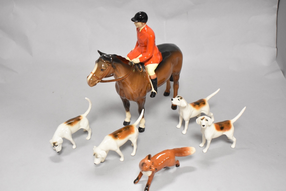 A Beswick pottery figure, The huntsman, four hounds in various poses and a fox.