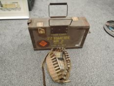 A wood and metal Ammunition box along with a canvas ammunitions belt with cartridges and bullets
