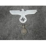 A German WWII metal large plaque, Eagle looking left gripping Swastika in wreath, wingspan 60cm