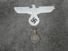 A German WWII metal large plaque, Eagle looking left gripping Swastika in wreath, wingspan 60cm