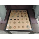 A framed display of twenty eight Canadian Military Cap Badges including Toronto Scottish, 1st