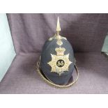 A late 19th/early 20th century 55th of Foot Black Cloth Spiked Helmet with cap badge and chin strap,