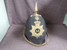 A late 19th/early 20th century 55th of Foot Black Cloth Spiked Helmet with cap badge and chin strap,