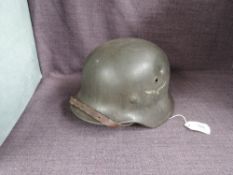 A German WWII Steel Helmet, possible M40 Luftwaffe, having leather liner and chin strap, no