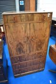 A 1930's Art Deco period walnut tallboy, having An arrangement of drawers and cupboards, each with