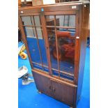 An early 20th century oak book case and cupboard with glazed doors.