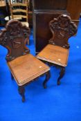 A fabulous pair of 19th Century oak hall chairs with Walker family motto/coat of arms to cartouche