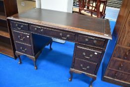 An Edwardian oak pedestal desk, the rectangular top with moulded edge detail enclosing the tooled