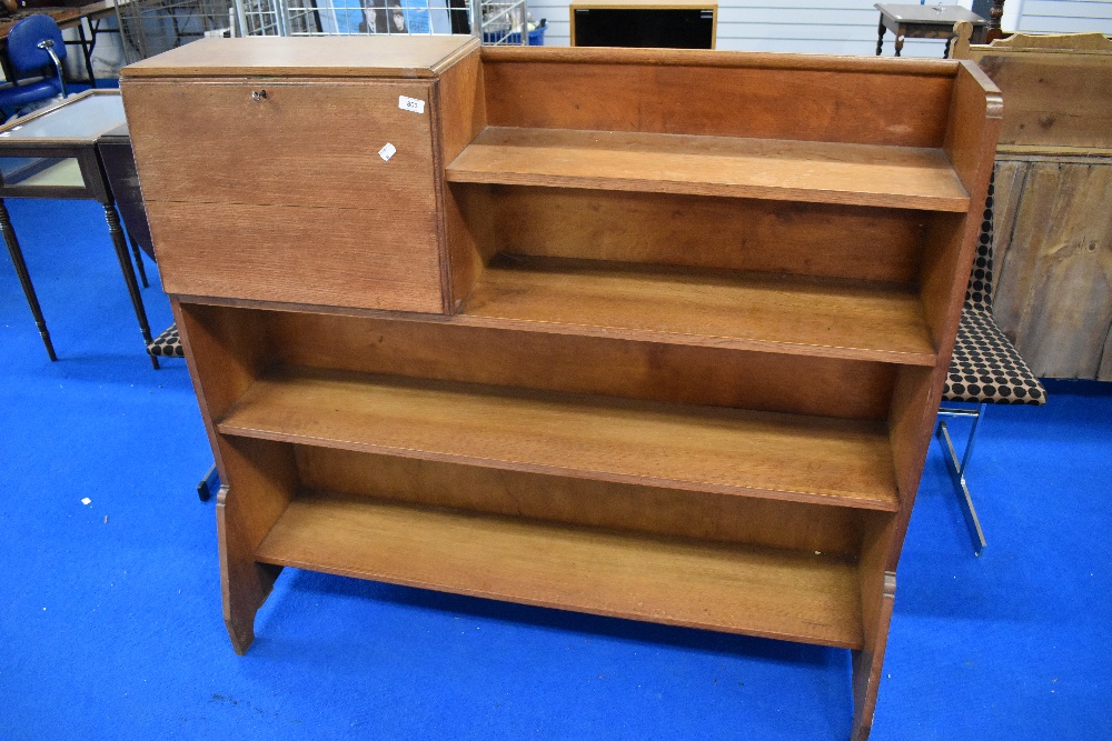 An Arts and Crafts golden oak bookshelf with bureau section, in the Arthur Simpson style with