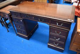 A reproduction mahogany pedestal desk, of traditional arrangement, the top with decorative