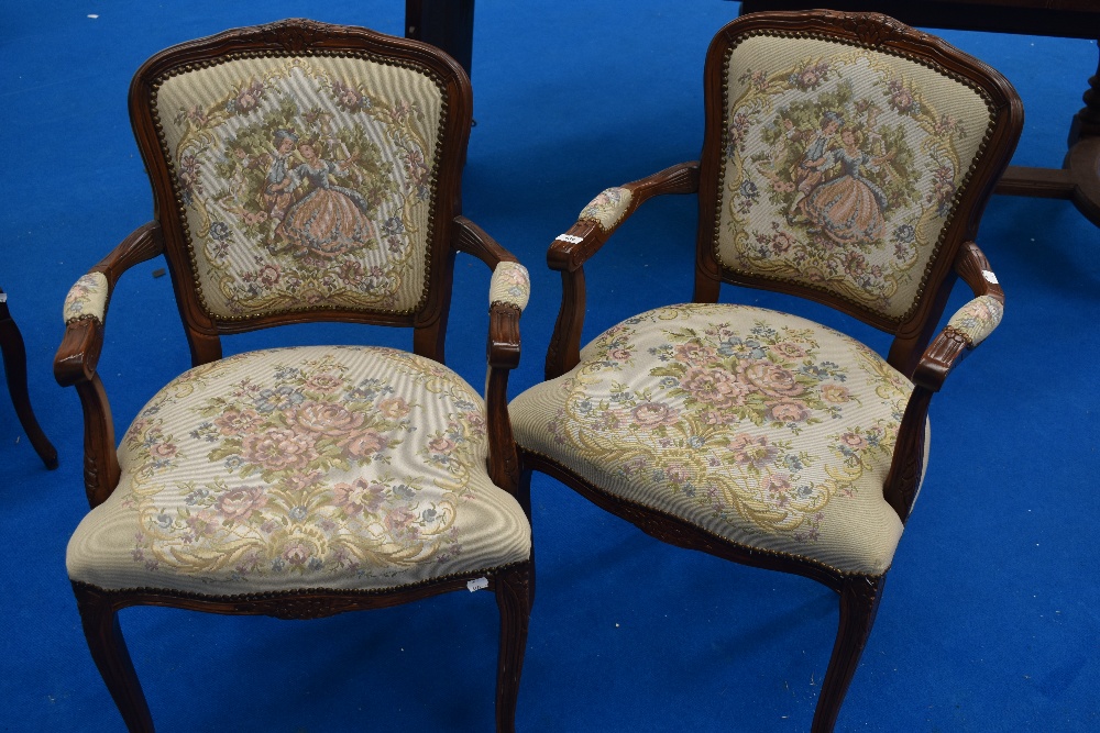 A pair of reproduction Continental style armchairs with tapestry style upholstery