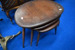 A vintage dark stained Ercol pebble style nest of tables