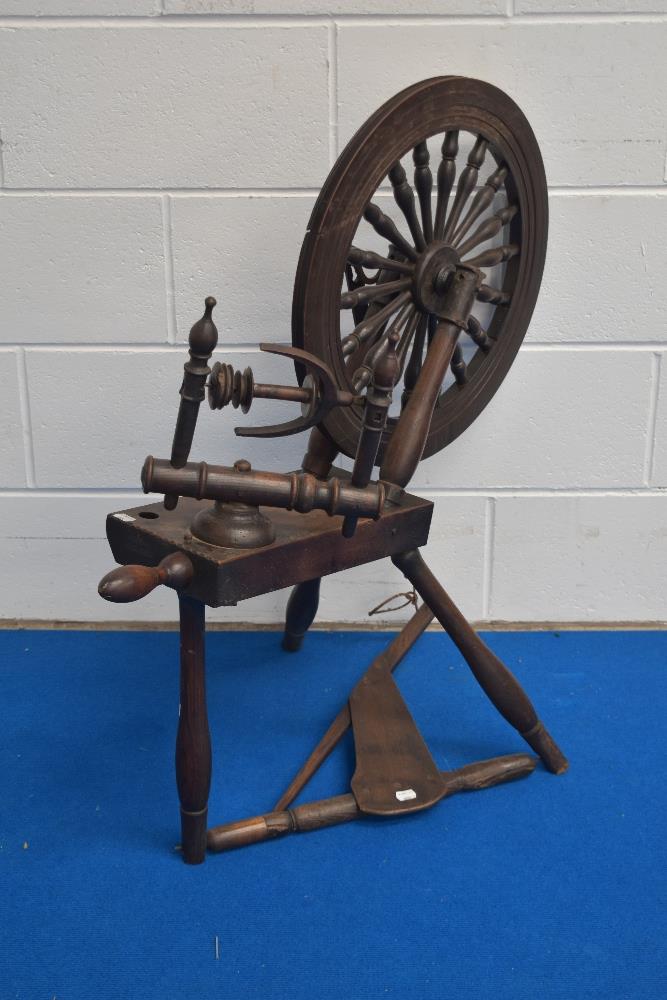 A 19th century spinning wheel, with notch carved block, turned supports and rails, the wheel with