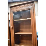 A modern Ercol mid stain bookcase with cupboard under