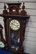 A Victorian Vienna style wall mounted clock with an enamel face and carved mahogany frame.