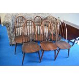 A set of six Ercol high hoop and stick back kitchen chairs in dark stain with H stretchers