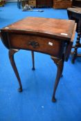 A reproduction walnut drop leaf side table, havoing a quarter-veneered and cross banded top with