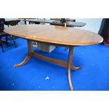 A modern Ercol or Parker Knoll style oval extending dining table, having whale tail style legs,