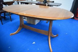 A modern Ercol or Parker Knoll style oval extending dining table, having whale tail style legs,