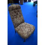 A Victorian nursing or boudoir chair having turned mahogany legs and stuffed seat and back with