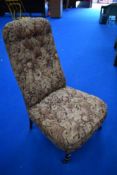 A Victorian nursing or boudoir chair having turned mahogany legs and stuffed seat and back with