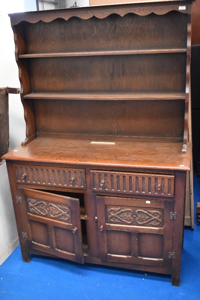 A Priory Oak style dresser, of traditional arrangement with plate rack over drawers and cupboards,