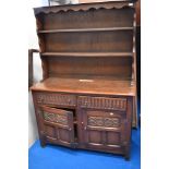 A Priory Oak style dresser, of traditional arrangement with plate rack over drawers and cupboards,