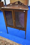 An Edwardian mahogany and inlaid corner display on tapered legs with spade feet