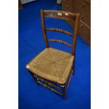 A 19th Cetury oak framed bobbin back kitchen chair with rush seat and a later cane seated carver