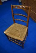 A 19th Cetury oak framed bobbin back kitchen chair with rush seat and a later cane seated carver