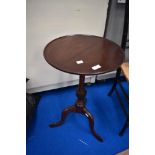 A late 19th or early 20th Century mahogany wine table having circular top on turned column and