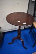 A late 19th or early 20th Century mahogany wine table having circular top on turned column and