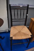 A 19th Century stained frame bedroom chair having turned frame and seagrass seat