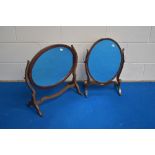 Two Edwardian mahogany swing mirrors, each of oval form and pivoted between curved supports and