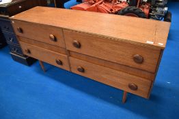 A 1970's teak four drawer chest or small sideboard, each drawer with two turned wooden handles,