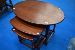 An Old Charm nest of three tables, retailed by Wood Brothers Limited, the largest with oval top