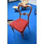 A Victorian balloon back chair with carved legs and back.